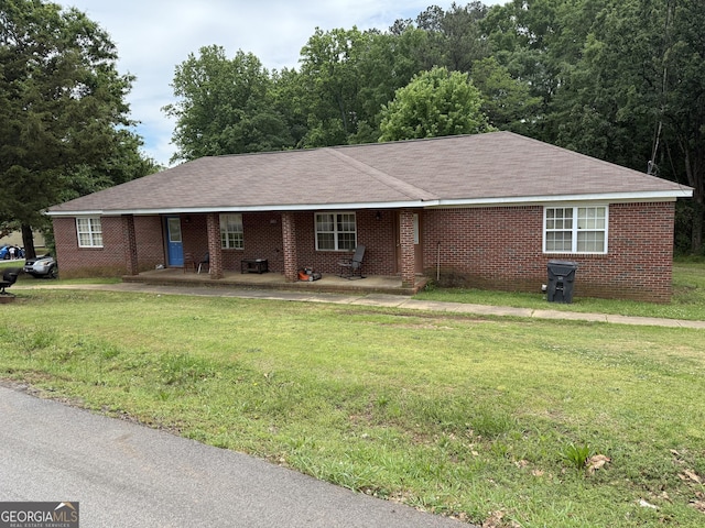 241 E Ash St, Social Circle, GA 30025 - ranch-style home featuring a front lawn, roof with shingles, and brick siding