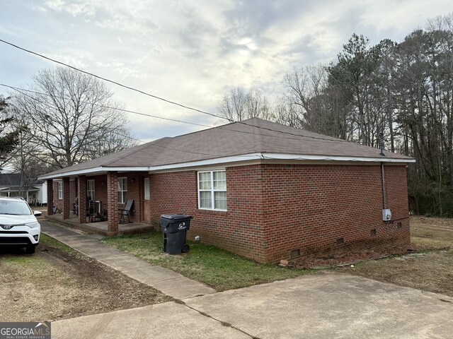 241 E Ash St, Social Circle, GA 30025 - view of side of property featuring covered porch, brick siding, and crawl space