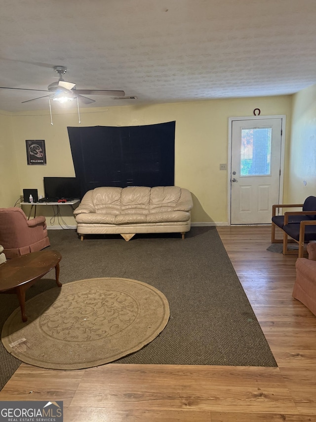 living room featuring wood-type flooring and ceiling fan