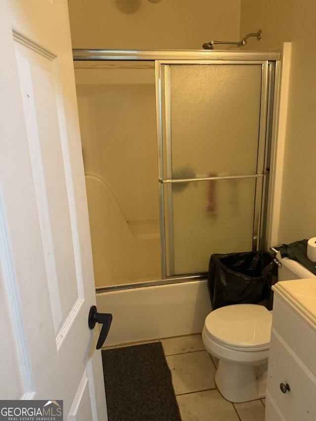 full bathroom with bath / shower combo with glass door, vanity, toilet, and tile patterned flooring