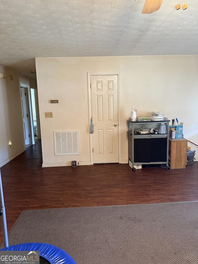 241 E Ash St, Social Circle, GA 30025 - interior space featuring a textured ceiling, visible vents, wood finished floors, and baseboards
