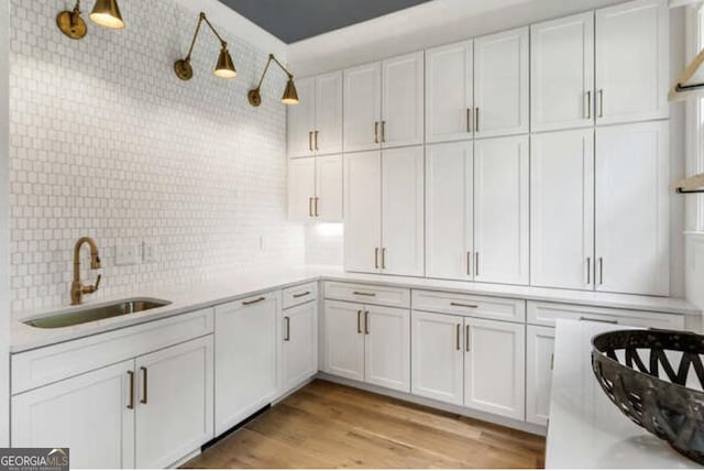 kitchen with decorative light fixtures, sink, and white cabinets