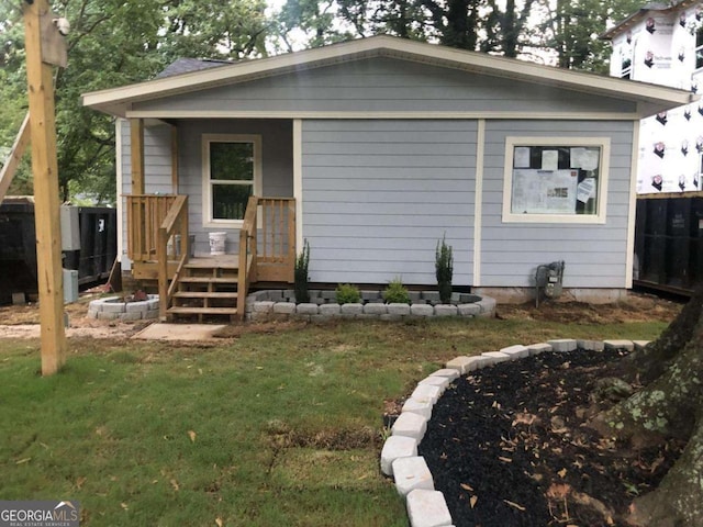 rear view of house featuring a lawn