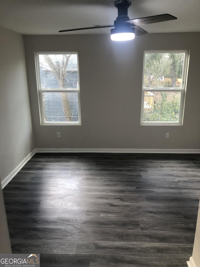 empty room featuring dark wood-type flooring and ceiling fan