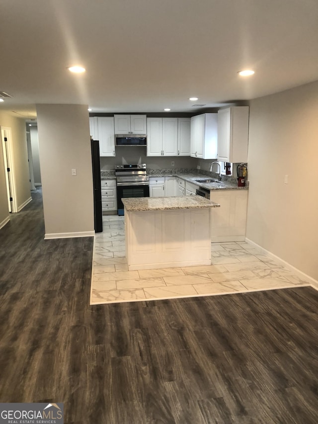 kitchen featuring sink, black fridge, stainless steel range with electric stovetop, light stone countertops, and exhaust hood