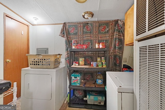 laundry area with washer and clothes dryer, cabinets, and a textured ceiling