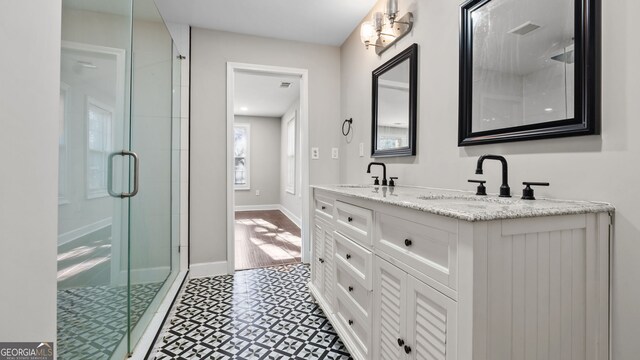 2183 Pansy St NW, Atlanta, GA 30314 - bathroom featuring a shower stall, double vanity, and baseboards