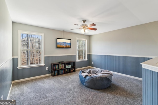 living area with ceiling fan and carpet flooring