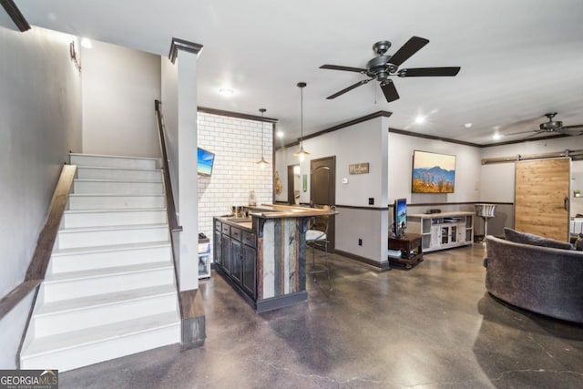 interior space with ornamental molding, a barn door, and ceiling fan