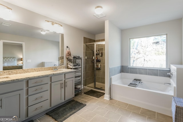 bathroom with independent shower and bath, vanity, and tile patterned floors