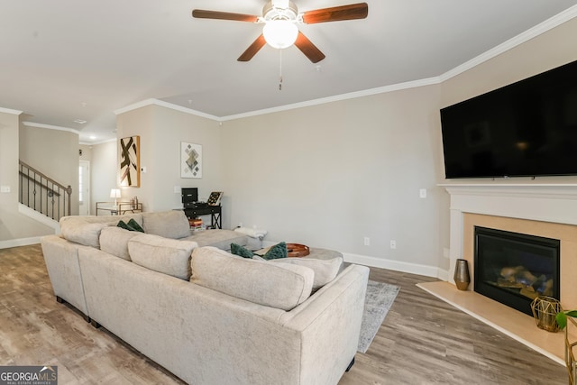 living room with ceiling fan, ornamental molding, and wood-type flooring