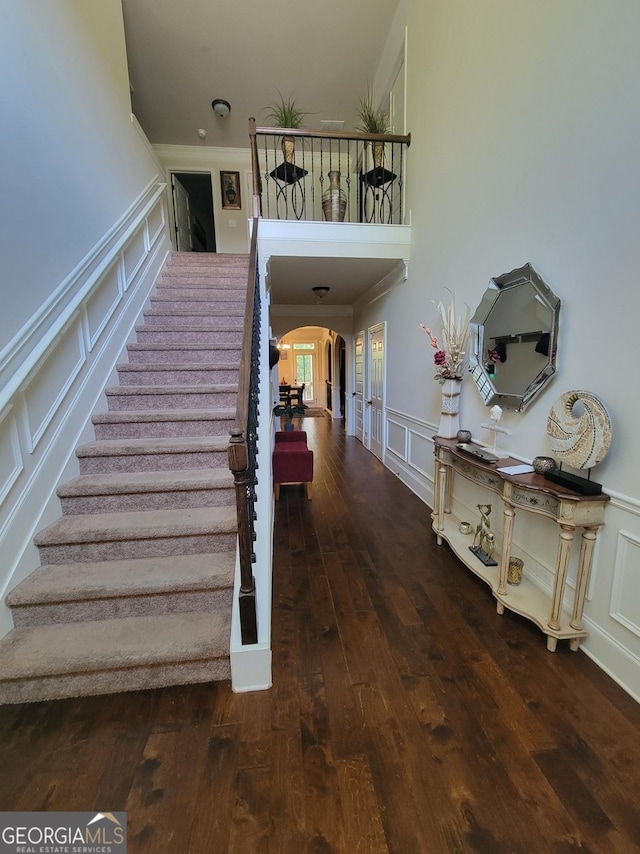 stairway featuring ornamental molding and wood-type flooring