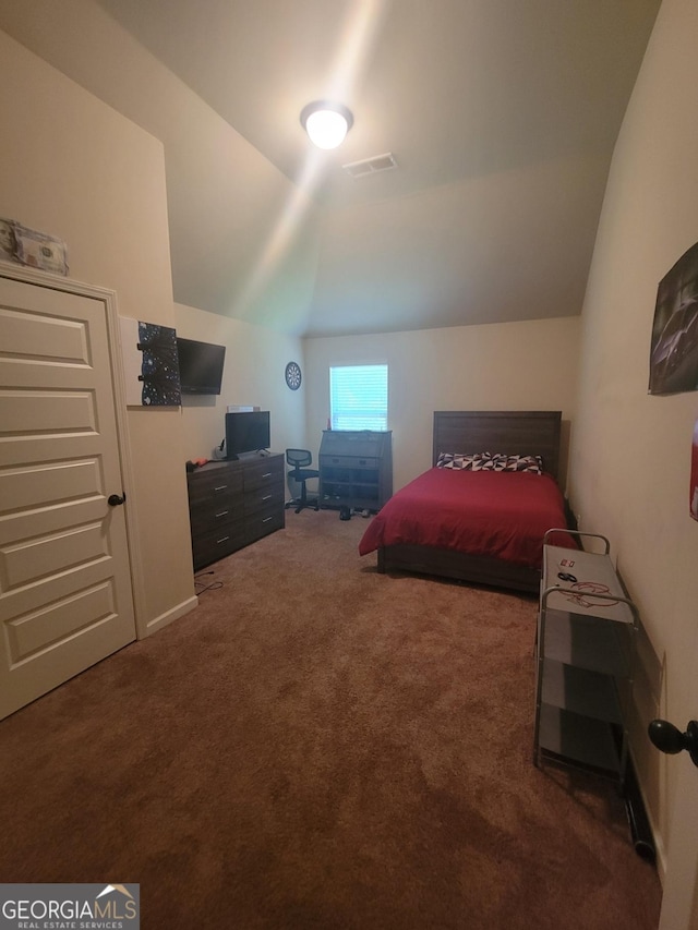 carpeted bedroom with lofted ceiling