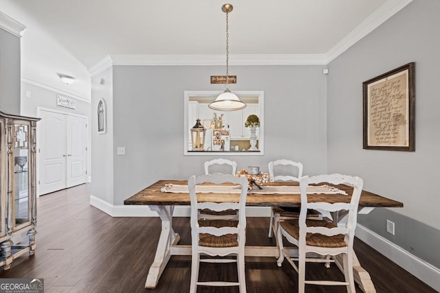 dining area featuring crown molding, baseboards, and wood finished floors