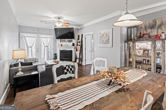 dining space with ornamental molding, dark hardwood / wood-style floors, ceiling fan, and french doors