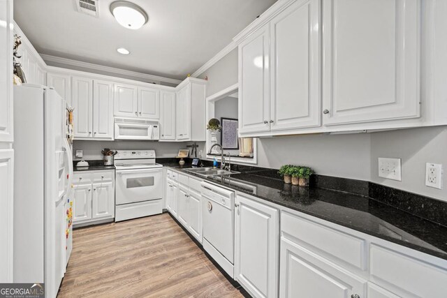 kitchen with white cabinetry, white appliances, sink, and dark stone countertops