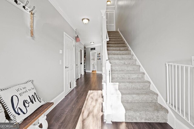 stairway with hardwood / wood-style floors and ornamental molding