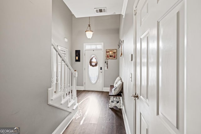 entrance foyer with visible vents, baseboards, dark wood-style floors, and stairs