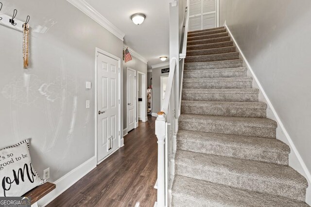 stairs featuring ornamental molding and hardwood / wood-style floors