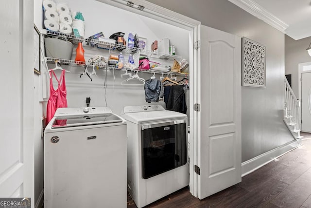 clothes washing area with dark wood-type flooring, ornamental molding, separate washer and dryer, baseboards, and laundry area