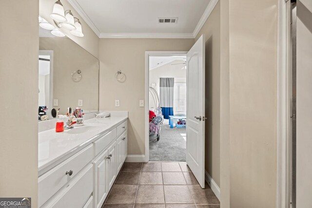 bathroom with visible vents, crown molding, tile patterned flooring, baseboards, and vanity