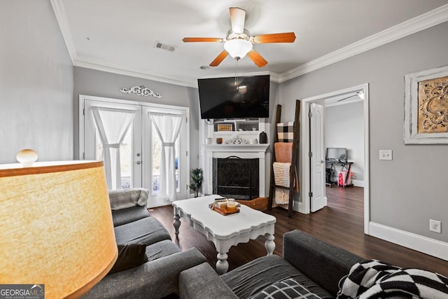 living room featuring baseboards, ornamental molding, a fireplace, french doors, and wood finished floors