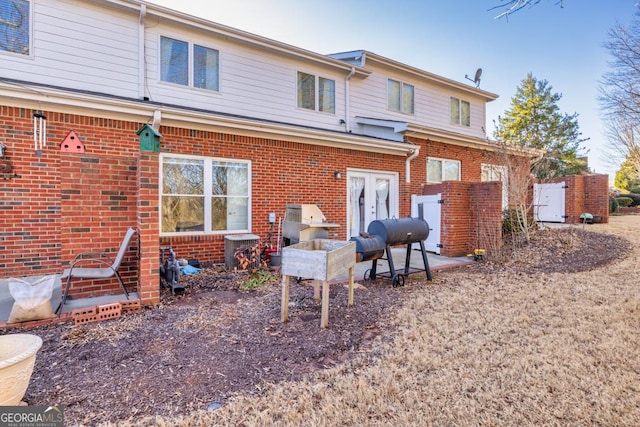 rear view of property with french doors and brick siding