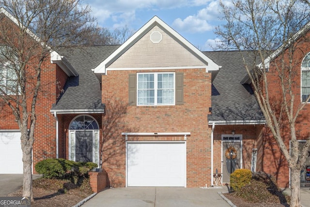 traditional home featuring brick siding, concrete driveway, an attached garage, and a shingled roof