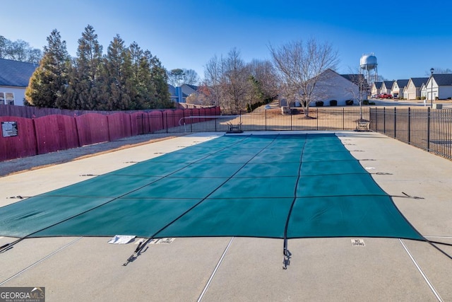 pool with a patio and fence