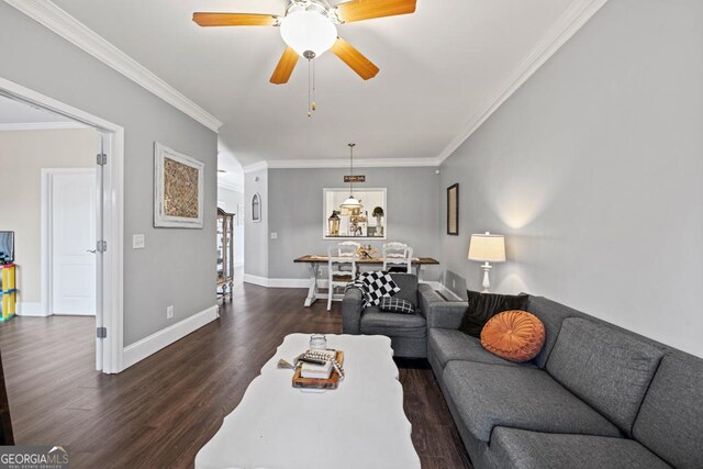 living room featuring dark wood-type flooring, ornamental molding, and ceiling fan