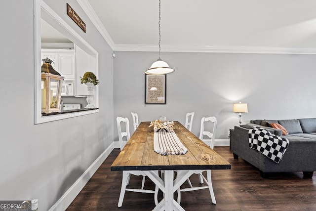 dining room with baseboards, wood finished floors, and ornamental molding