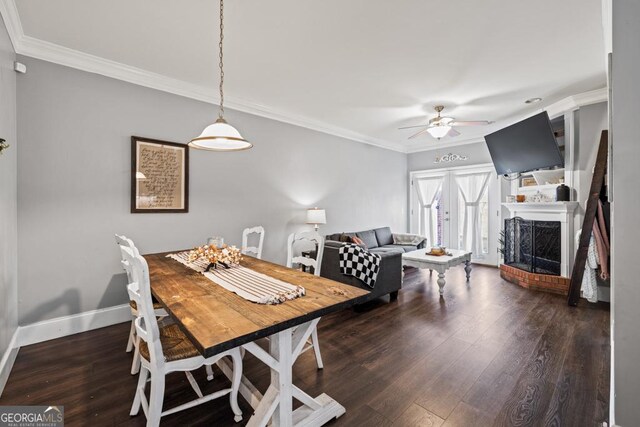 dining room with crown molding, a fireplace, dark hardwood / wood-style floors, and ceiling fan