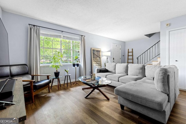 living room featuring dark hardwood / wood-style floors and a textured ceiling