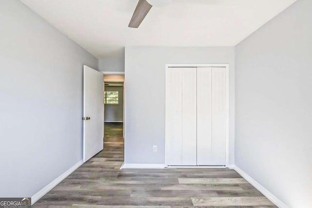 unfurnished bedroom featuring hardwood / wood-style flooring, ceiling fan, and a closet