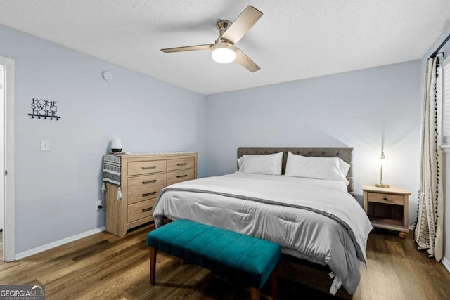 bedroom featuring a textured ceiling, dark hardwood / wood-style floors, and ceiling fan