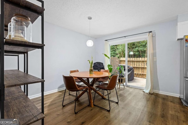 dining room featuring dark hardwood / wood-style floors and a textured ceiling