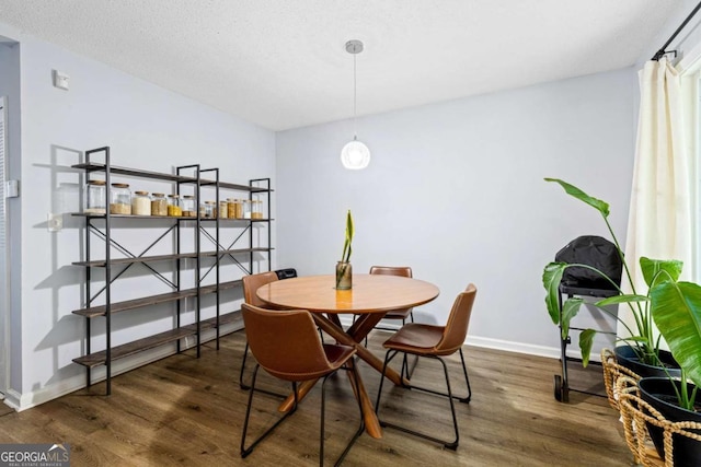 dining space featuring dark hardwood / wood-style flooring and a textured ceiling