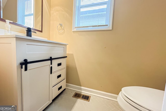 bathroom featuring vanity, tile patterned flooring, and toilet