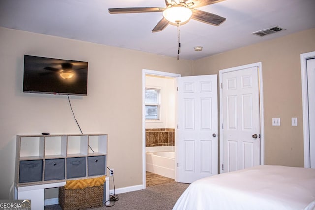 bedroom with ceiling fan, ensuite bathroom, and carpet flooring