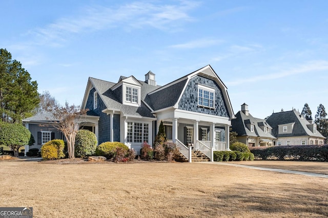 view of front of home with a porch and a front yard