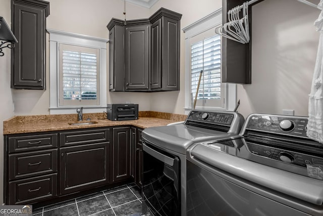 washroom with cabinets, separate washer and dryer, sink, and dark tile patterned flooring