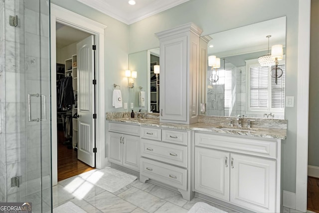 bathroom with ornamental molding, vanity, and walk in shower