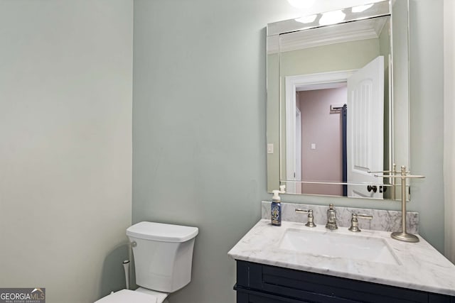 bathroom with vanity, ornamental molding, and toilet