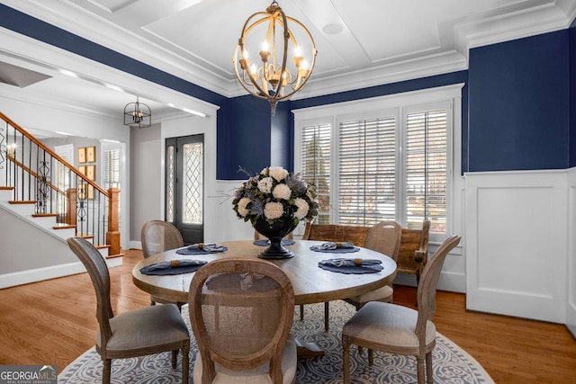 dining area with a notable chandelier, crown molding, and hardwood / wood-style floors