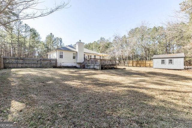 view of yard featuring a wooden deck and a storage unit