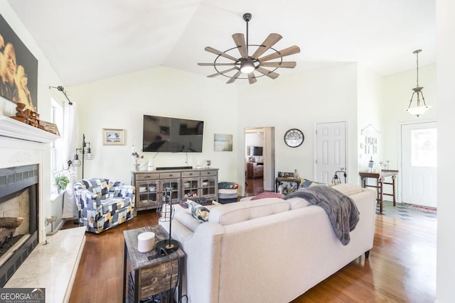 living room featuring a fireplace, dark hardwood / wood-style floors, ceiling fan, and vaulted ceiling