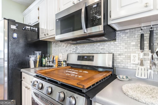 kitchen featuring appliances with stainless steel finishes, white cabinets, and decorative backsplash