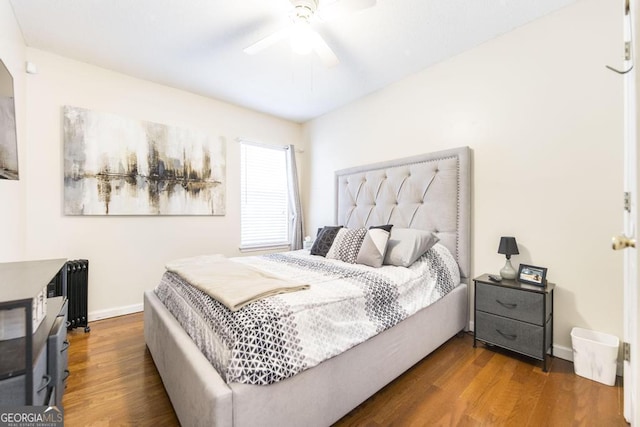 bedroom with hardwood / wood-style floors, radiator, and ceiling fan