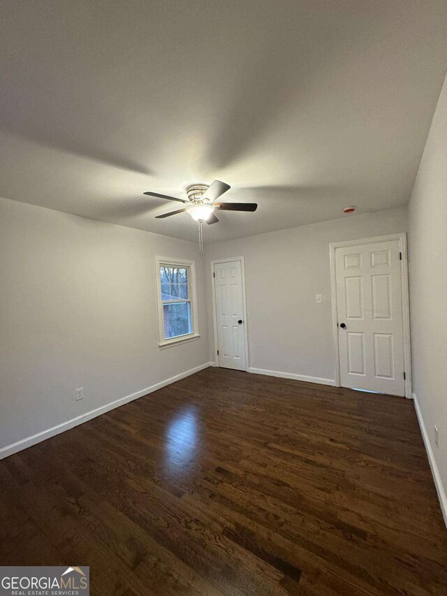 empty room featuring dark hardwood / wood-style flooring and a notable chandelier