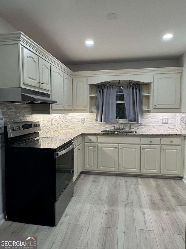 kitchen with sink, tasteful backsplash, white cabinets, stainless steel electric stove, and light wood-type flooring